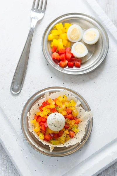 Hard boiled quail eggs with capsicum in cheese basket — Stock Photo, Image