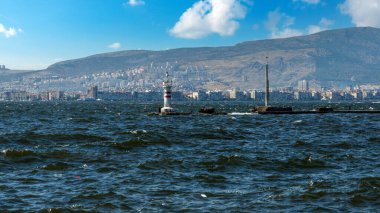 Modern binalar ve gemilerle kıyı kenti. Türkiye 'nin İzmir kentinin orta kesiminde, setin kenarında belirsiz insanlar yürüyor
