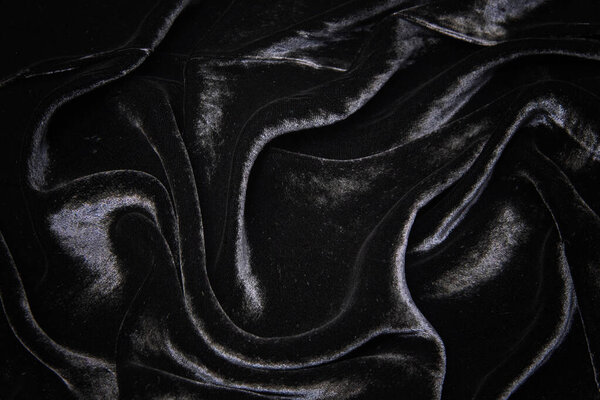Velvet silk or cotton or wool fabric tissue. Dark gray or black color. Texture, background, pattern.
