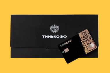 Moskova, Rissia - 31 Mart 2021: Black Metal Tinkoff Bank banka kartı ve kurumsal siyah zarf (Rusça: Tinkoff). Rus ticari bankası Oleg Tinkov tarafından kuruldu.