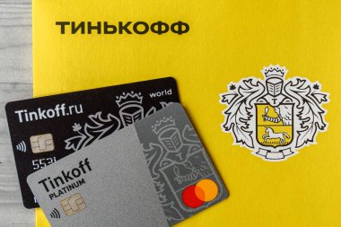 Moskova, Rissia - 11 Şubat 2021: Bitcoin, Black and Platinum Tinkoff Bank banka kartı ve şirket sarı zarfı (Rusça: Tinkoff). Rus ticari bankası Oleg Tinkov tarafından kuruldu.