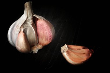 Karanlık ahşap desenli arka planda bir parça sarımsak kafası