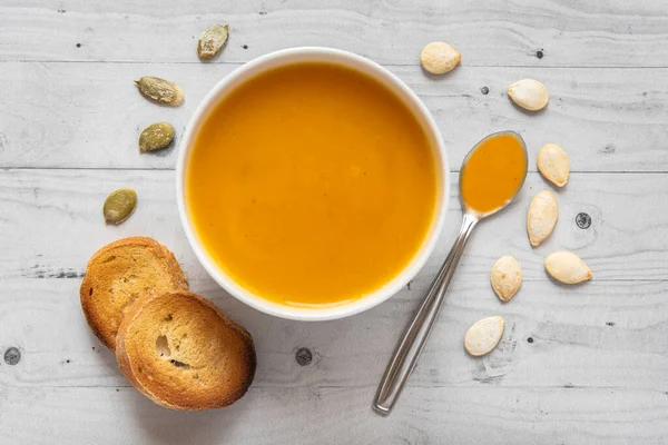 Kürbissuppe Mit Brot Auf Hellem Holzgrund Mit Löffel Und Kernen Stockbild