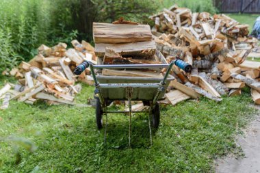 Dışarıda odun yığını ve el arabası var. Kış için hazırlık.