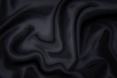 Siyah kumaş dokusu arka plan, dalgalı kumaş kaygan siyah renk, lüks saten ya da ipek ya da yün kumaş dokusu.