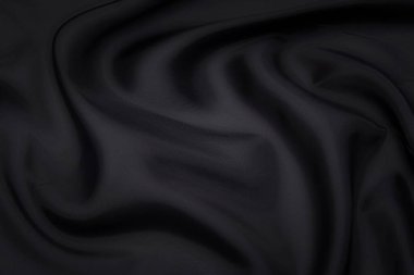 Siyah kumaş dokusu arka plan, dalgalı kumaş kaygan siyah renk, lüks saten ya da ipek ya da yün kumaş dokusu.