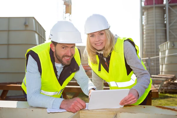 Workers on a construction studying blueprints — Stock Photo, Image