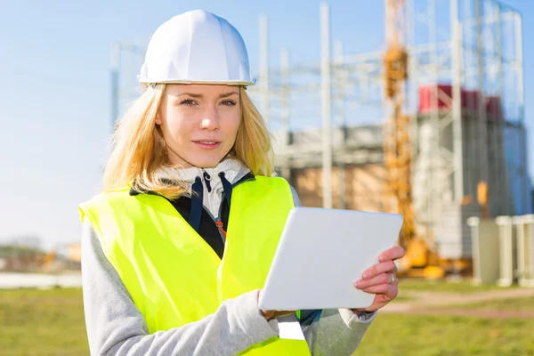 Retrato de uma mulher trabalhadora atraente em um canteiro de obras — Fotografia de Stock