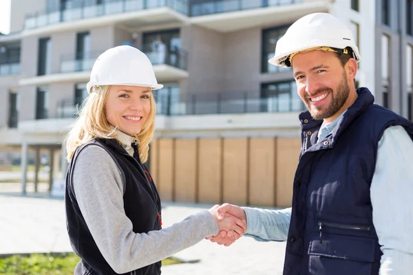 Arquiteto e trabalhador handshaking no canteiro de obras — Fotografia de Stock