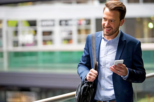 Jonge aantrekkelijke zakenman gebruikend smartphone — Stockfoto