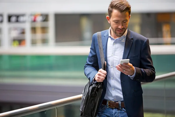 Jonge aantrekkelijke zakenman gebruikend smartphone — Stockfoto