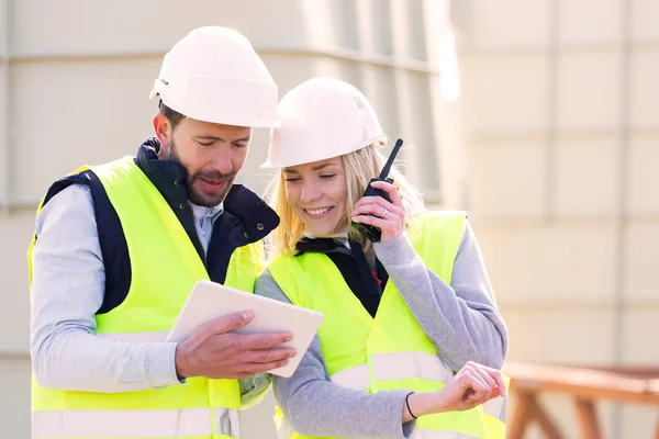 Trabajadores en una construcción estudiando planos — Foto de Stock