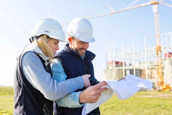 Dos trabajadores que trabajan fuera en una obra de construcción — Foto de Stock