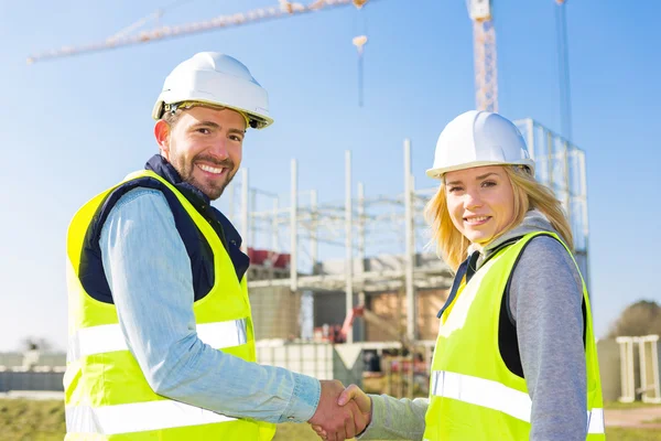 Arquitecto y trabajador apretón de manos en el sitio de construcción — Foto de Stock
