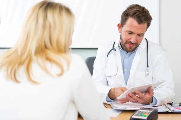 Young doctor watching results on tablet to patient — Stock Photo, Image