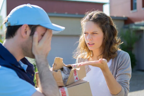 Young attractive woman angry against delivery man — Stock Photo, Image