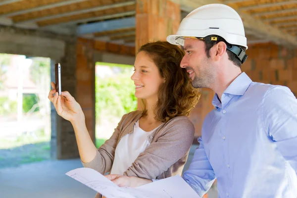 Mujer joven y arquitecto en obra — Foto de Stock