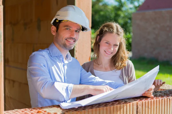 Young woman and architect on construction site — Stock Photo, Image