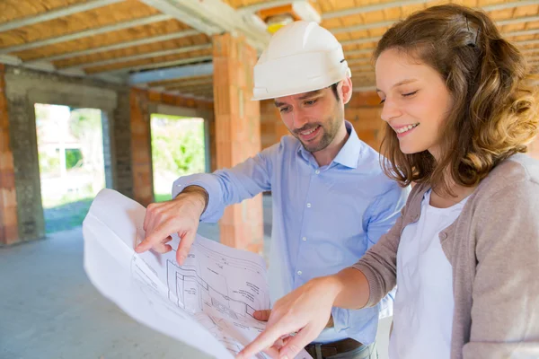 Mujer joven y arquitecto en obra — Foto de Stock