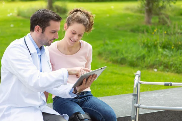 Médico mostrando dicas de reeducação em tablet — Fotografia de Stock