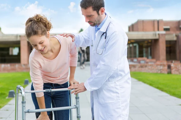 Joven médico asistiendo a una joven mujer — Foto de Stock