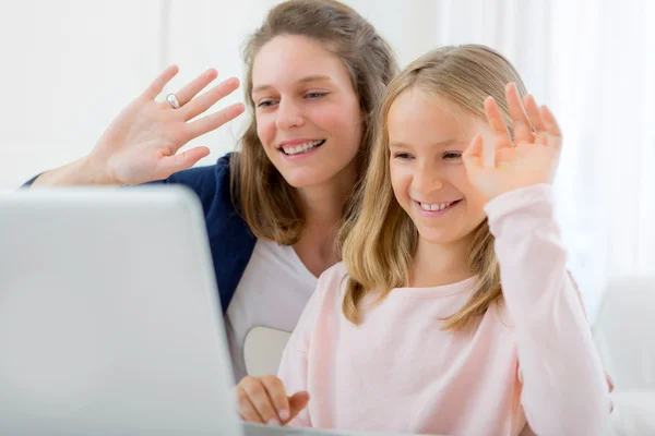 Attractive woman and little sister videocalling — Stock Photo, Image