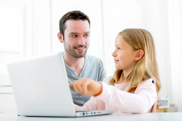Pai e sua filha loira usando laptop — Fotografia de Stock