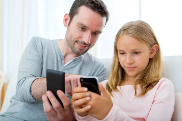 Padre y su hija rubia usando móvil — Foto de Stock