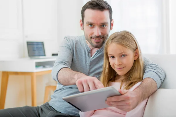 Padre y su hija rubia usando tableta — Foto de Stock