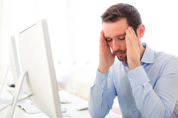 Junger attraktiver Mann hat Kopfschmerzen im Büro — Stockfoto