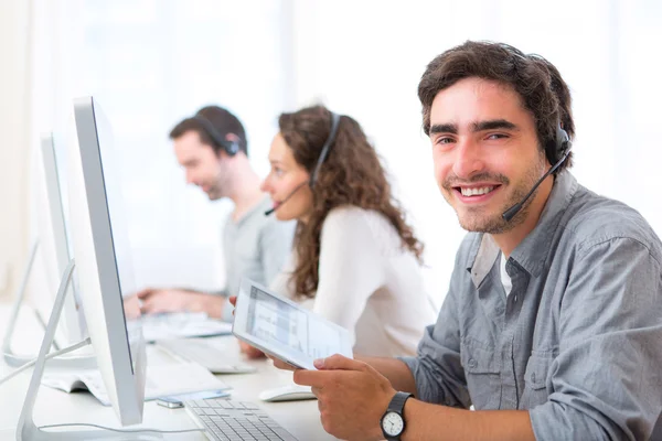 Giovane uomo attraente che lavora in un call center — Foto Stock