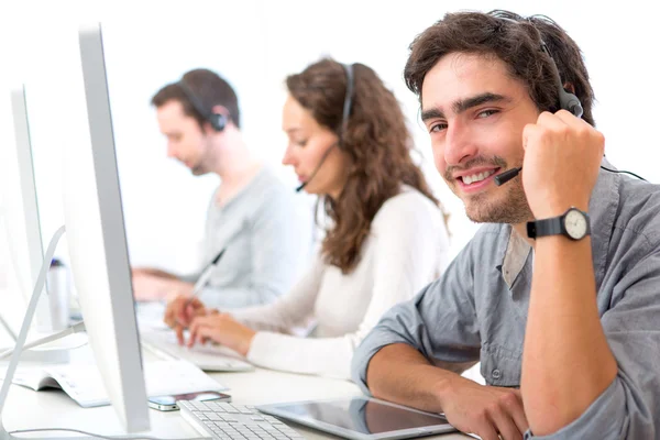 Jovem homem atraente trabalhando em um call center — Fotografia de Stock