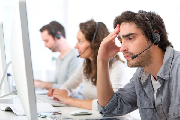 Aantrekkelijke jongeman ziek-bij-gemak op het werk — Stockfoto