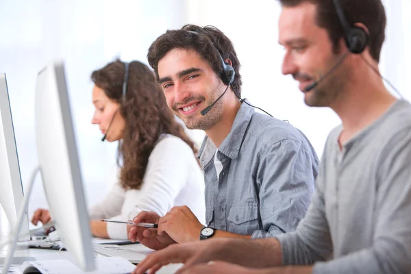 Giovane uomo attraente che lavora in un call center — Foto Stock