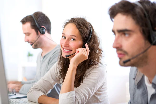 Giovane donna attraente che lavora in un call center — Foto Stock