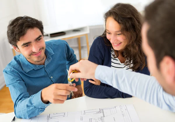 Real estate handing over keys to couple — Stock Photo, Image