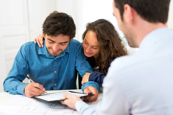 Young attractive couple signing contract — Stock Photo, Image