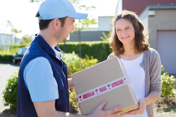 Delivery man handing over a parcel to customer — Stock Photo, Image