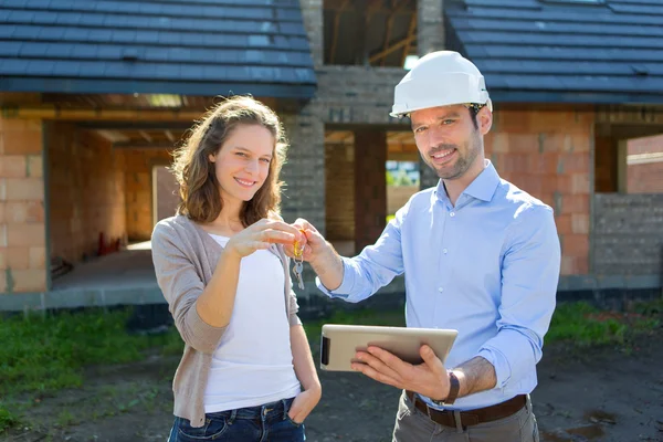 Mujer joven y arquitecto en obra — Foto de Stock