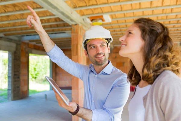 Mujer joven y arquitecto en obra — Foto de Stock