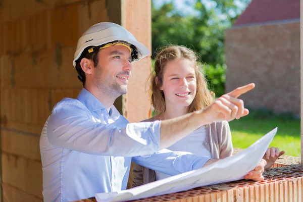 Mujer joven y arquitecto en obra — Foto de Stock