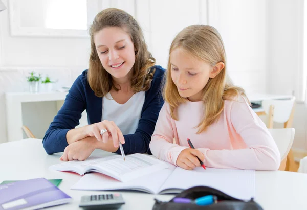 Vrouw om haar kleine zusje voor huiswerk te helpen — Stockfoto