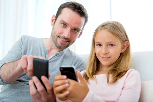 Father and his blond daughter using mobile — Stock Photo, Image