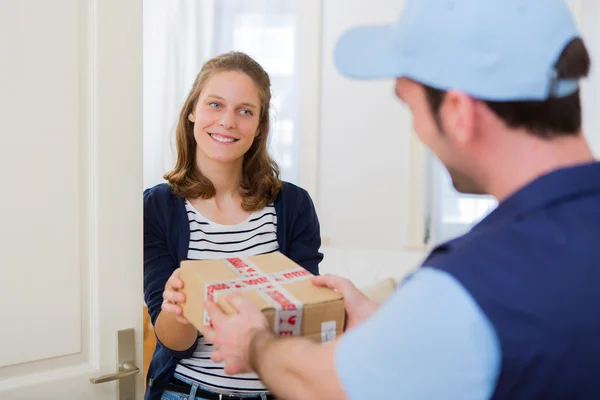 Delivery man handing over a parcel to customer — Stock Photo, Image