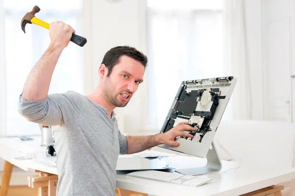 Young attractive man angry against computer — Stock Photo, Image