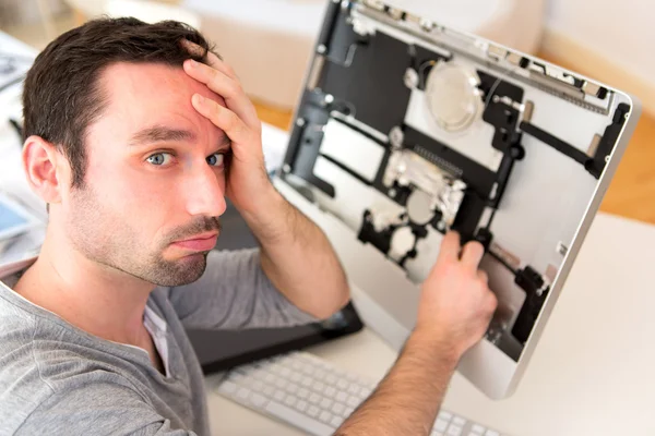 Jovem atraente homem tentando reparar computador — Fotografia de Stock