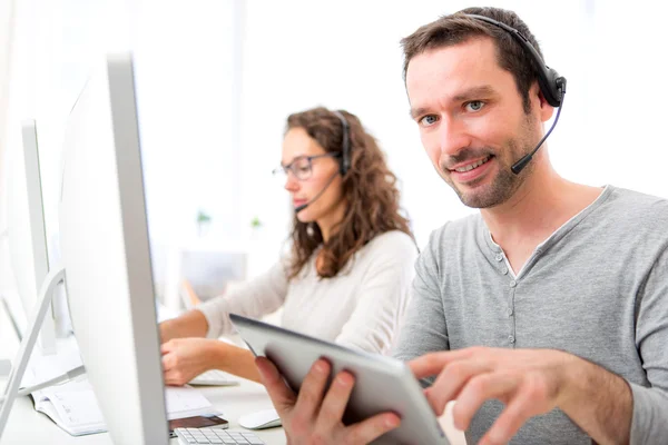 Giovane uomo attraente che lavora in un call center — Foto Stock