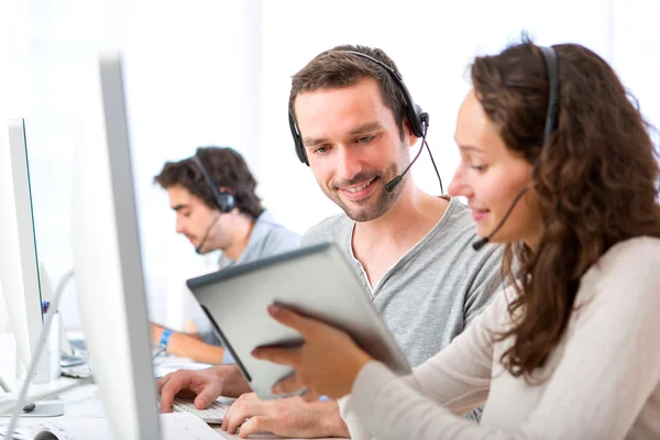 Jonge aantrekkelijke vrouw die werkt in een callcenter — Stockfoto