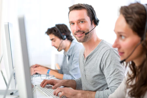 Jovem homem atraente trabalhando em um call center — Fotografia de Stock