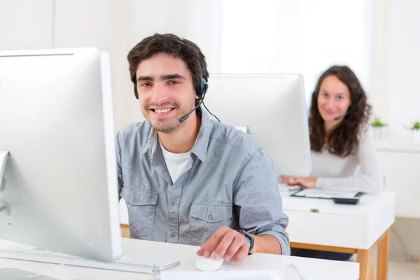 Aantrekkelijke jongeman werken in een callcenter — Stockfoto